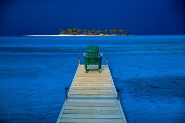 Adirondack chair on a wooden dock.