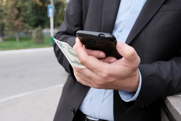 A business person is interested in looking at a smartphone on the street. The concept of business style of modern man. The Absorption Of The Internet