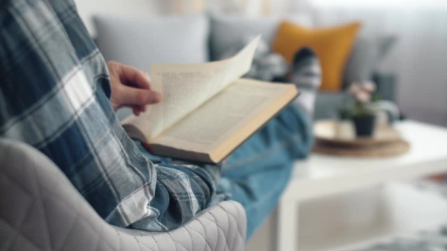 Man seat on chair in living room and read book. Relaxing after work. Lifestyle. 4k slow motion footage.