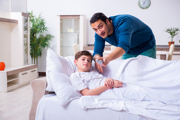 Obraz premium Young father caring for sick son