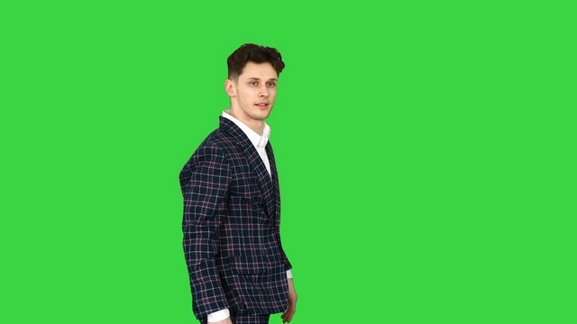 Businessman makes a back flip and shows cool gesture to camera after on a Green Screen, Chroma Key.