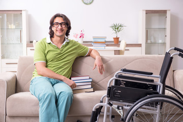 Young male student in wheelchair at home