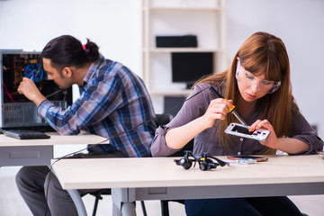 Two technicians working at computer warranty center