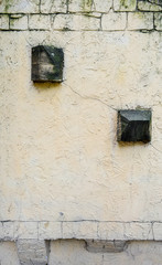 Texture of light yellow paint stucco on brick wall. Imitation of old castle wall
