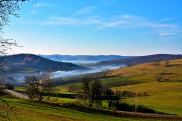 late autumn landscape with fog between the hills