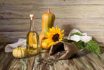 Sunflower seeds and sunflower oil on a wooden background