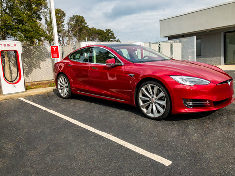 Tesla Red Model S Supercharging Electric Car Plugged In