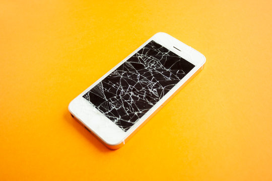 Broken screen of smartphone on the orange background. Smashed glass of cell phone, illustration for repair, fix phone services. Side
