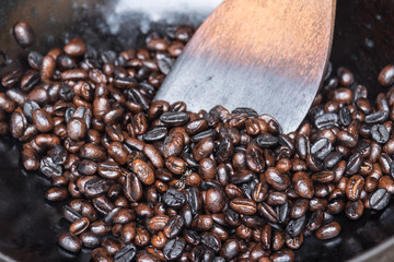 Coffee beans in a pan and spatula
