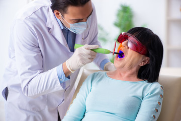 Naklejka premium Old woman visiting young doctor dentist
