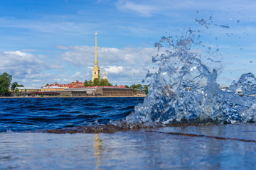 Obraz premium Saint-Petersburg. Rivers Of St. Petersburg. Peter and Paul fortress on the Neva. The water splashes on the granite embankment. City of Russia. Summer landscape of St. Petersburg