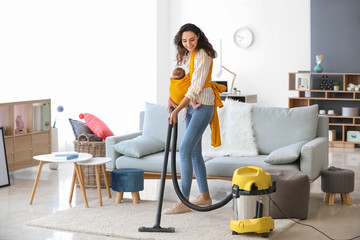 Young mother with little baby doing chores at home