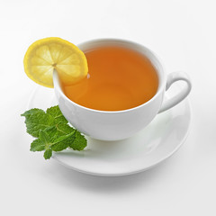 Cup of tasty tea with lemon and mint on white background