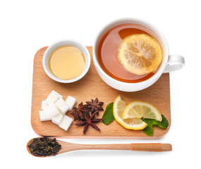Cup of hot tea with lemon, honey and spices on white background