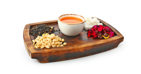 Cup of tasty tea with sugar and nuts on white background