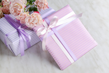 Gift boxes and beautiful flowers on light background
