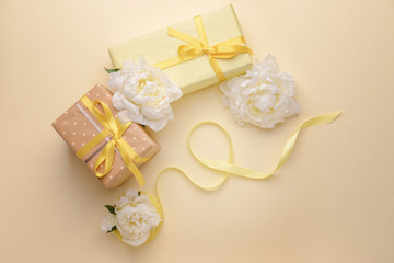 Fototapeta na wymiar Gift boxes and beautiful flowers on color background