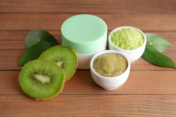 Cosmetics with kiwi on wooden table