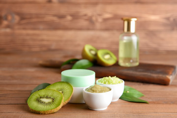 Cosmetics with kiwi on wooden table