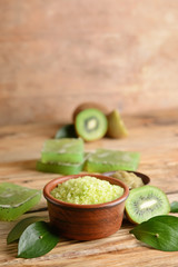 Cosmetics with kiwi on wooden table