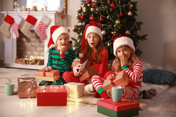 Fototapeta na wymiar Surprised little children with Christmas gifts at home