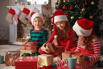 Fototapeta na wymiar Cute little children with Christmas gifts at home
