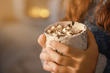 Cute little girl with hot chocolate on Christmas eve at home, closeup