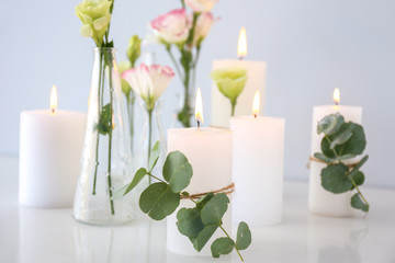 Composition with beautiful burning candles and flowers on table