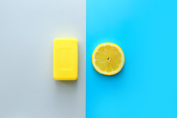 Soap bar with lemon slice on color background