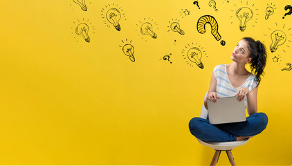 Question with light bulbs with young woman using a laptop computer