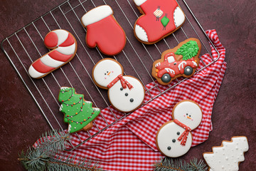 Cooling rack with tasty Christmas cookies on color background