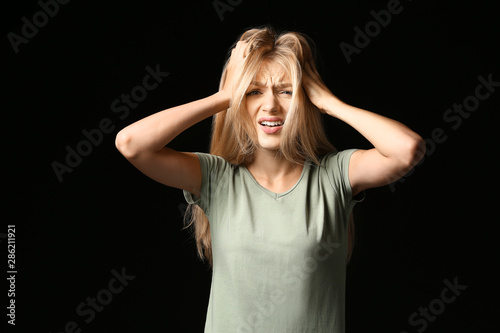 Stressed young woman on dark background