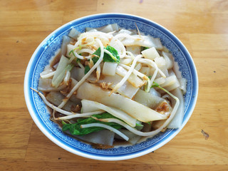 A bowl of rice noodles on wood table