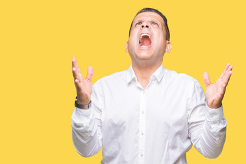 Naklejka premium Middle age arab elegant man over isolated background crazy and mad shouting and yelling with aggressive expression and arms raised. Frustration concept.