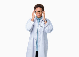 Young african american doctor woman wearing medical coat over isolated background with hand on head for pain in head because stress. Suffering migraine.