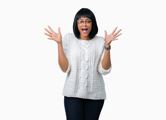 Beautiful young african american woman wearing glasses over isolated background celebrating crazy and amazed for success with arms raised and open eyes screaming excited. Winner concept