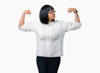 Beautiful young african american woman wearing glasses over isolated background showing arms muscles smiling proud. Fitness concept.