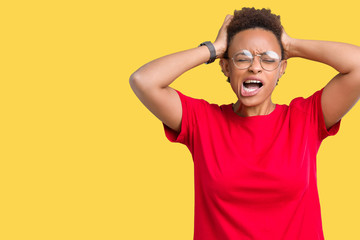 Fototapeta na wymiar Beautiful young african american woman wearing glasses over isolated background Crazy and scared with hands on head, afraid and surprised of shock with open mouth