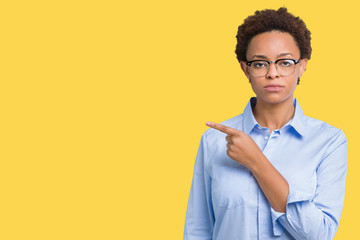 Fototapeta premium Young beautiful african american business woman over isolated background Pointing with hand finger to the side showing advertisement, serious and calm face