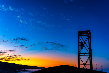 Silhouetted Tower on Hill at Sunrise or Sunset