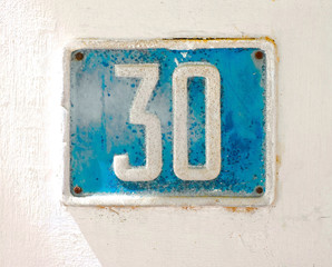 30, number thirty, grungy blue plate on white surface.