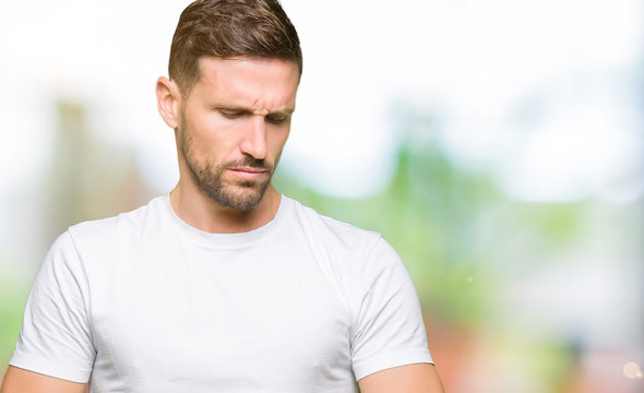 Handsome man wearing casual white t-shirt Checking the time on wrist watch, relaxed and confident