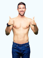 Fototapeta premium Handsome shirtless man showing nude chest success sign doing positive gesture with hand, thumbs up smiling and happy. Looking at the camera with cheerful expression, winner gesture.