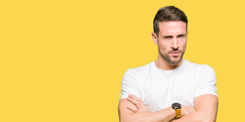Handsome man wearing casual white t-shirt skeptic and nervous, disapproving expression on face with...