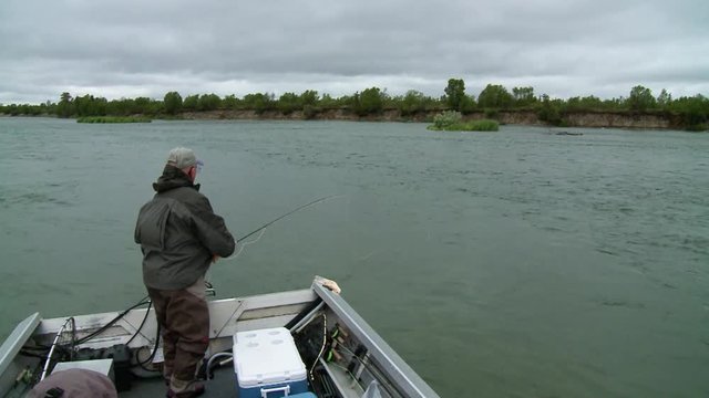 Male angler fly casting from boat