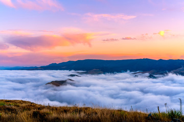 Pink Sunrise over Sea of Clouds and Mountains