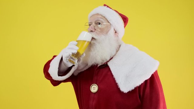 Santa Claus drinking a glass of beer. Rest time. Alcoholic drink at the holidays. Drink with moderation. Craft beer. Merry Christmas. Cinematic 4K.