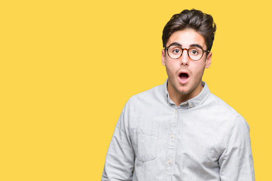 Young handsome man wearing glasses over isolated background In shock face, looking skeptical and sarcastic, surprised with open mouth