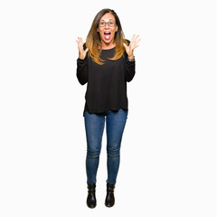 Obraz premium Beautiful middle age woman wearing glasses celebrating crazy and amazed for success with arms raised and open eyes screaming excited. Winner concept