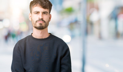 Young handsome man over isolated background skeptic and nervous, frowning upset because of problem. Negative person.